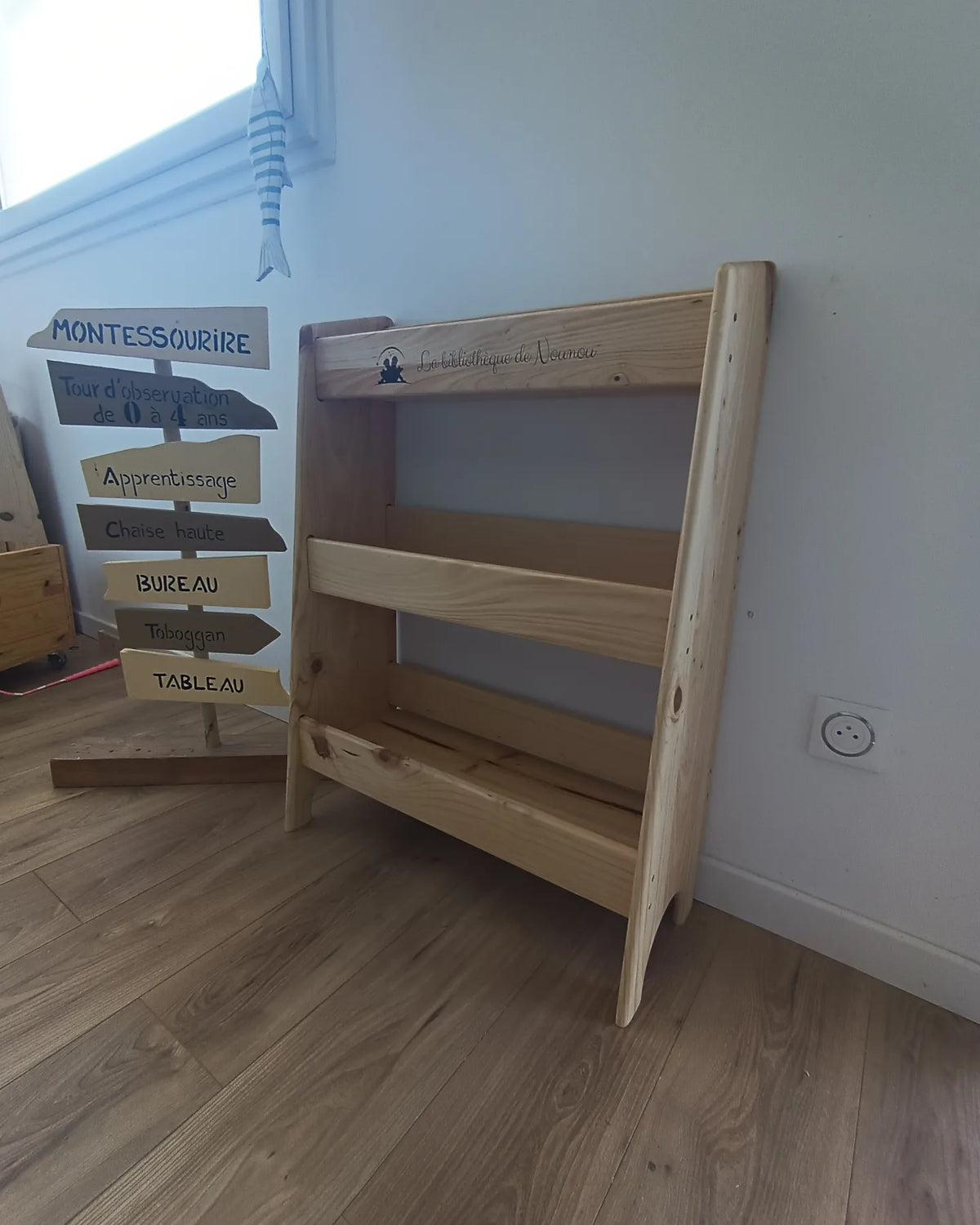 Bibliothèque Montessori artisanale en pin FSC, meuble bas favorisant l’autonomie.
